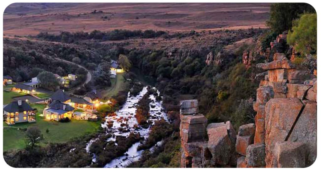 Scenic view of Kruger National Park with river and rocky cliffs at sunset.