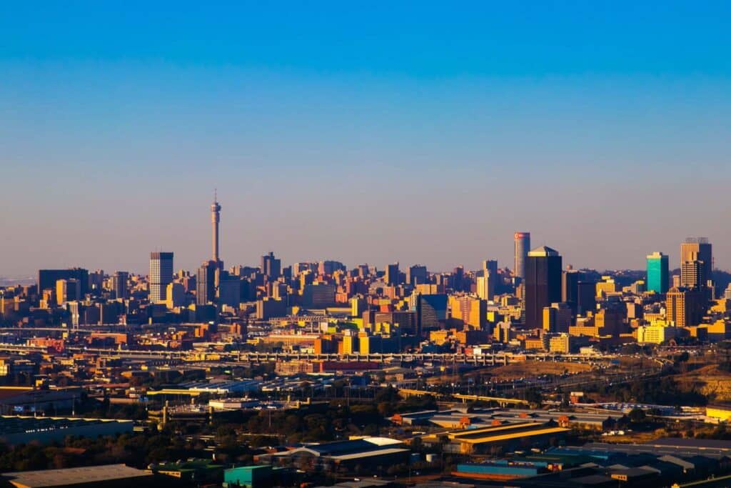Aerial view of Johannesburg skyline with tall buildings and clear blue sky.