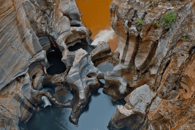 Blyde River Canyon with winding river and colorful rock formations.