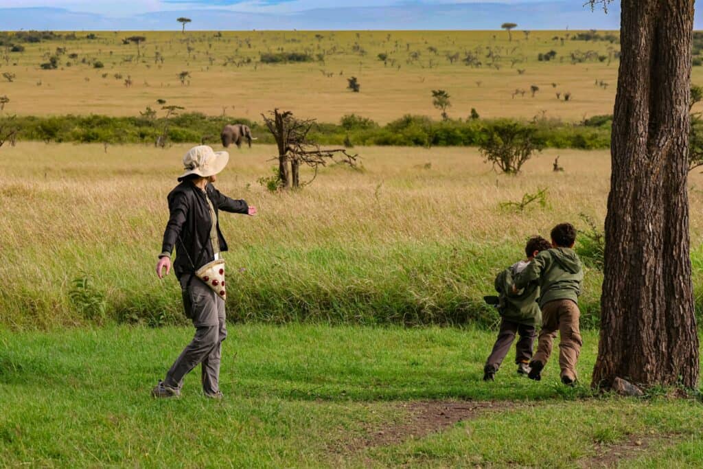 Family enjoying safari tour with elephants in the background.