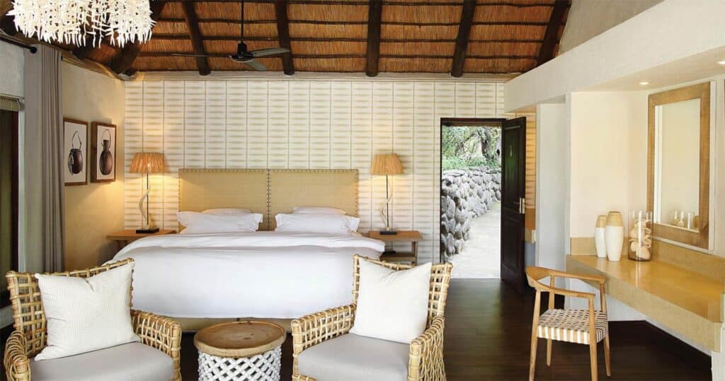 Elegant safari lodge room with comfortable bed and cozy seating area.