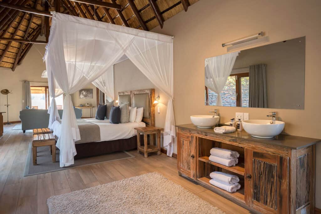 Elegant safari lodge bedroom with canopy bed and rustic decor.