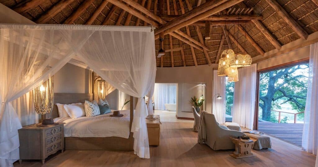 Elegant safari lodge room with canopy bed and panoramic views.