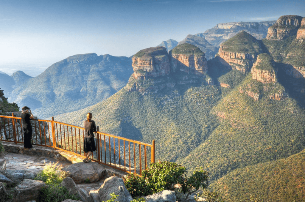 Visitors enjoying panoramic view of the Grand Canyon from a lookout point.