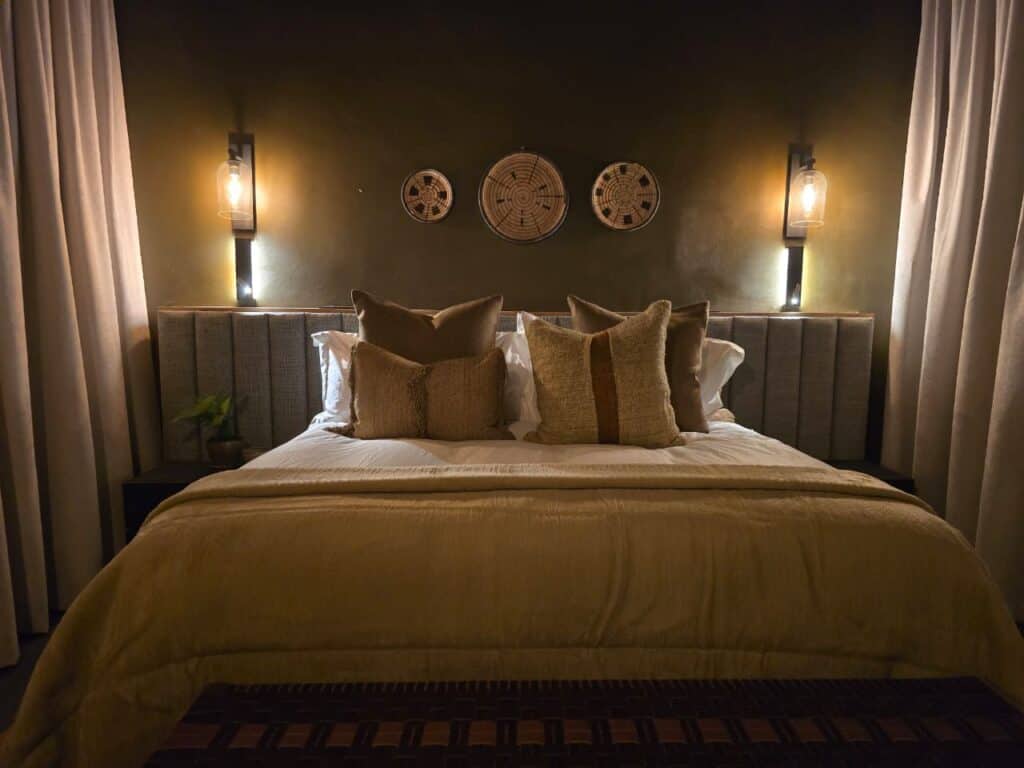 Elegant bedroom with cozy bedding and ambient lighting for luxury safari stay.