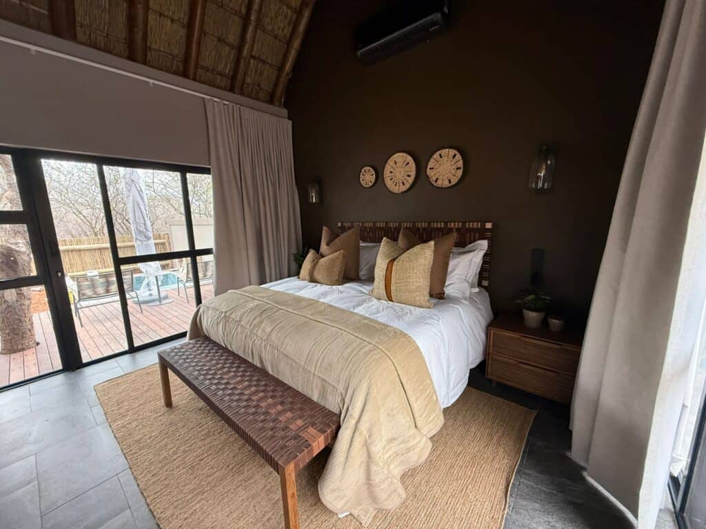 Elegant bedroom with large bed, wooden accents, and balcony view.