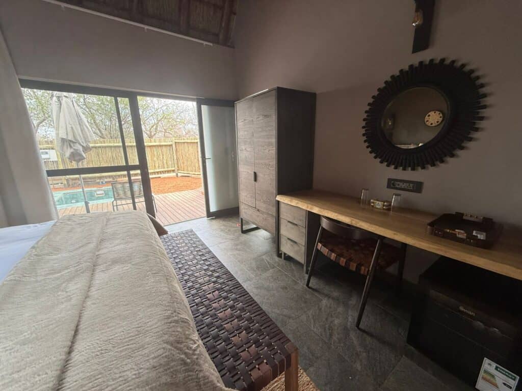 Elegant safari lodge room with balcony and pool view, perfect for a 5-day Ivory Moon & Greenfire saf.