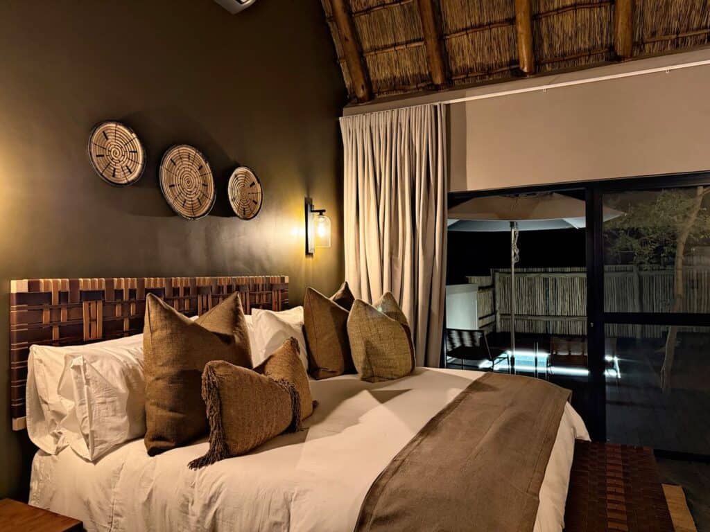 Elegant safari lodge bedroom with cozy bed and decorative wall art.