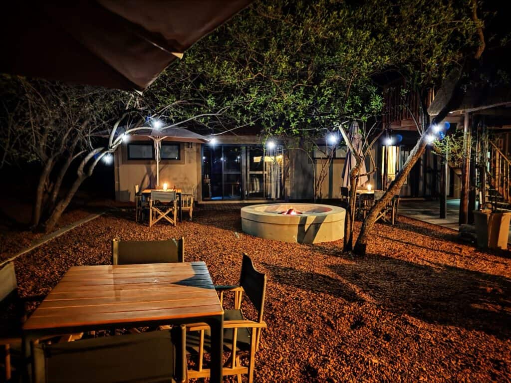 Night view of a luxury safari lodge with outdoor seating and ambient lighting.