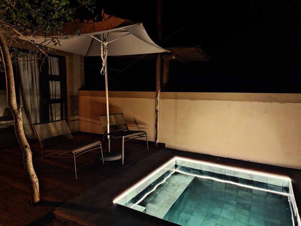 Nighttime pool with lighting, outdoor seating, and umbrella at Moafrika Tours.