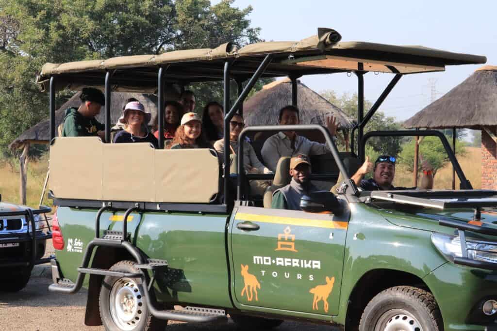 Group enjoying a private game drive in Pilanesberg National Park on an open safari vehicle.